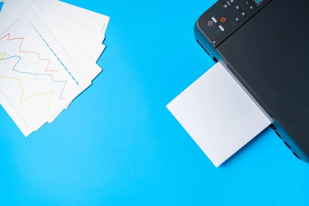 Nowoczesna drukarka z papierem na niebieskim tle