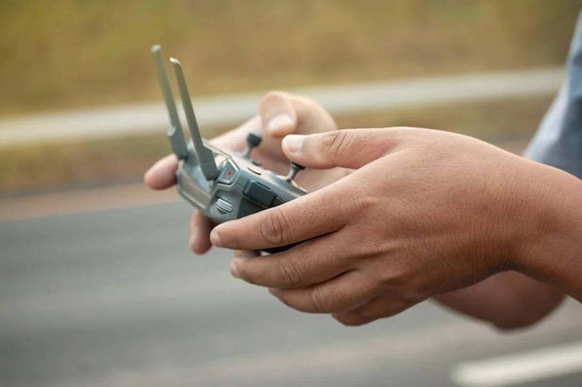 Człowiek trzymający zdalnie sterowane urządzenie